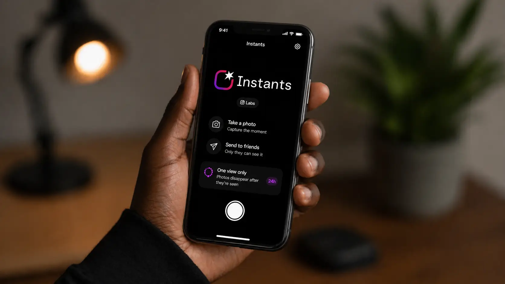 african hand holding smartphone with instants app meta open on screen