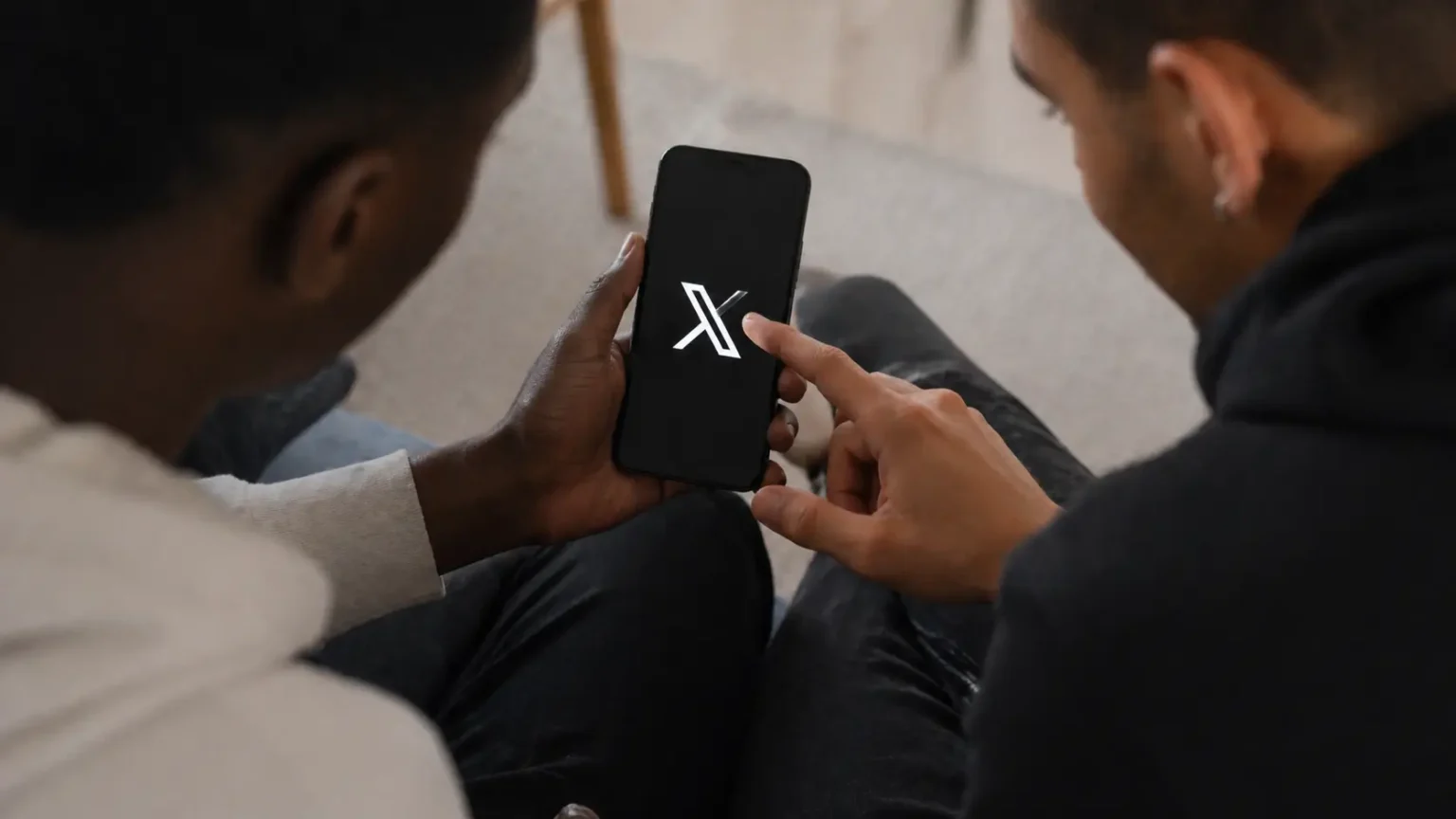 two people using smartphone together with XChat app iOS messaging interface on screen